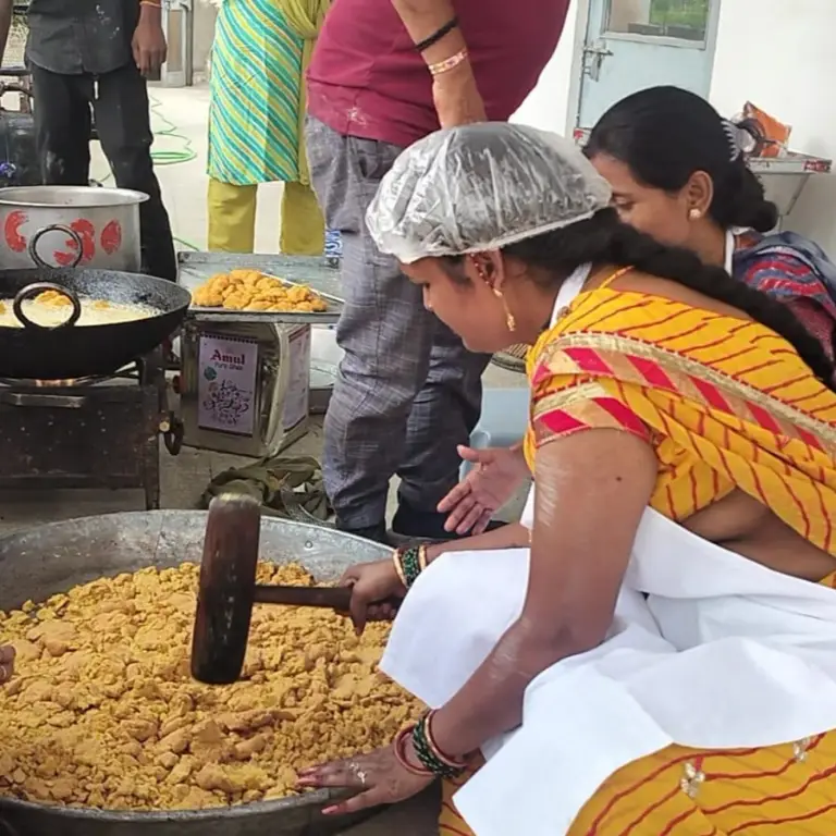 महिलाएँ स्थानीय बाजार में श्रीजी फ़ूड प्रोडक्ट्स बेच रही हैं।